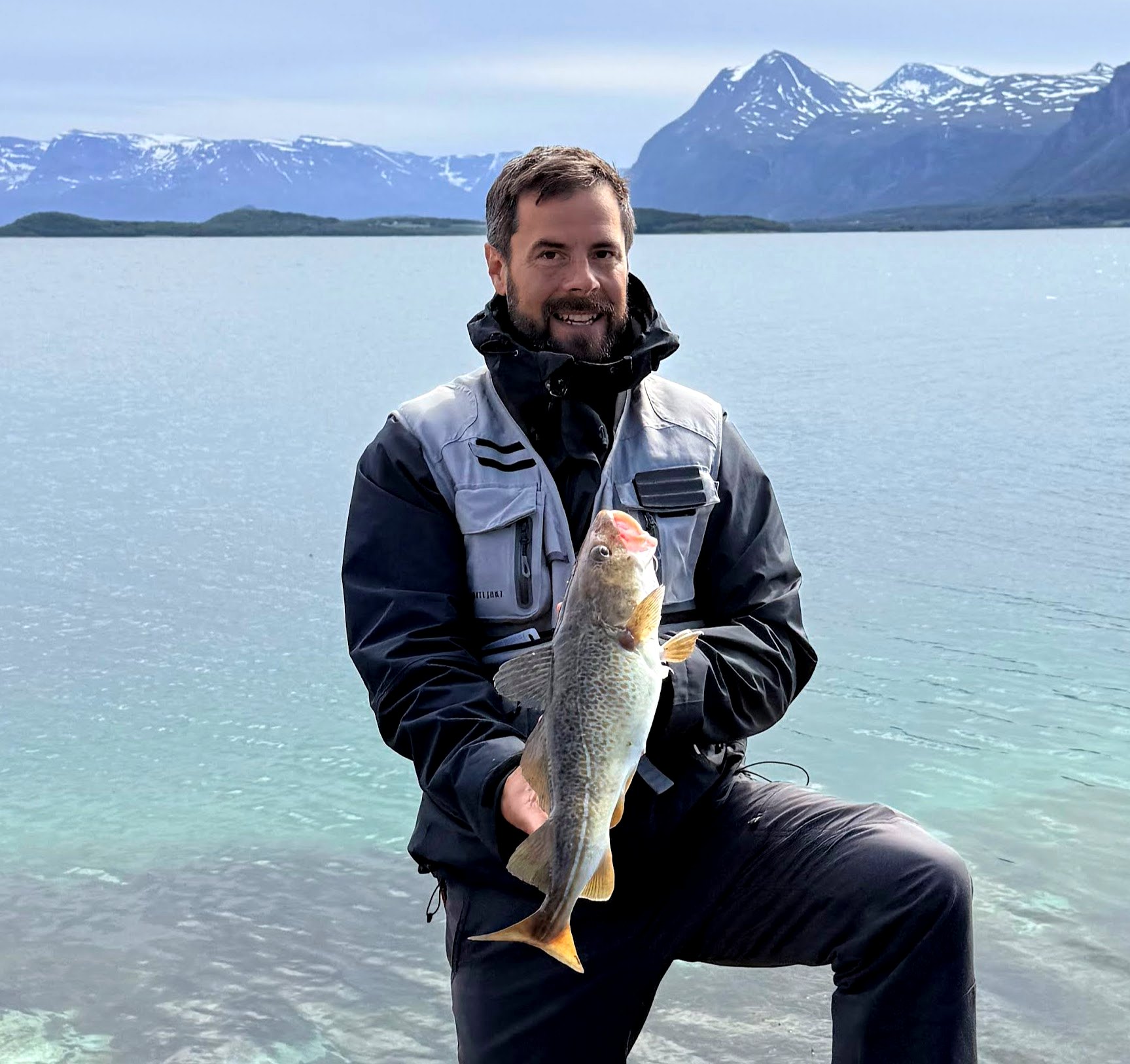 Guide with a large cod caught on an arctic fjord expedition