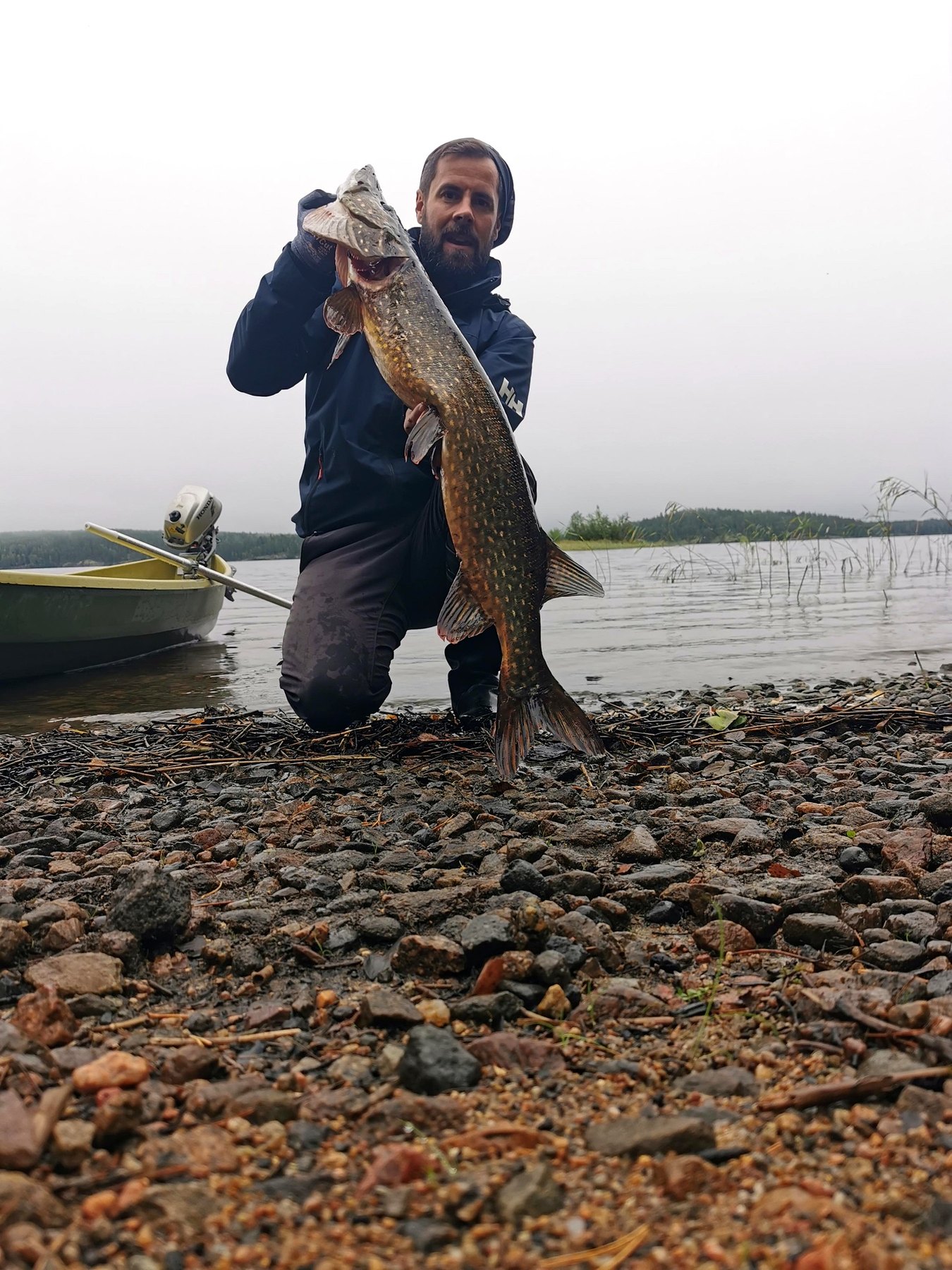 Trophy northern pike on a misty Finnish shore