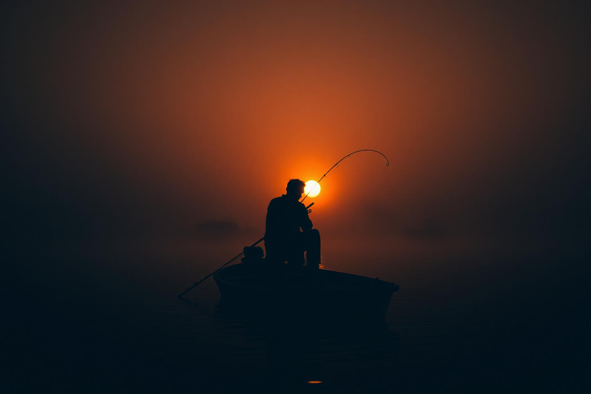 Fisherman on a Finnish lake at sunrise